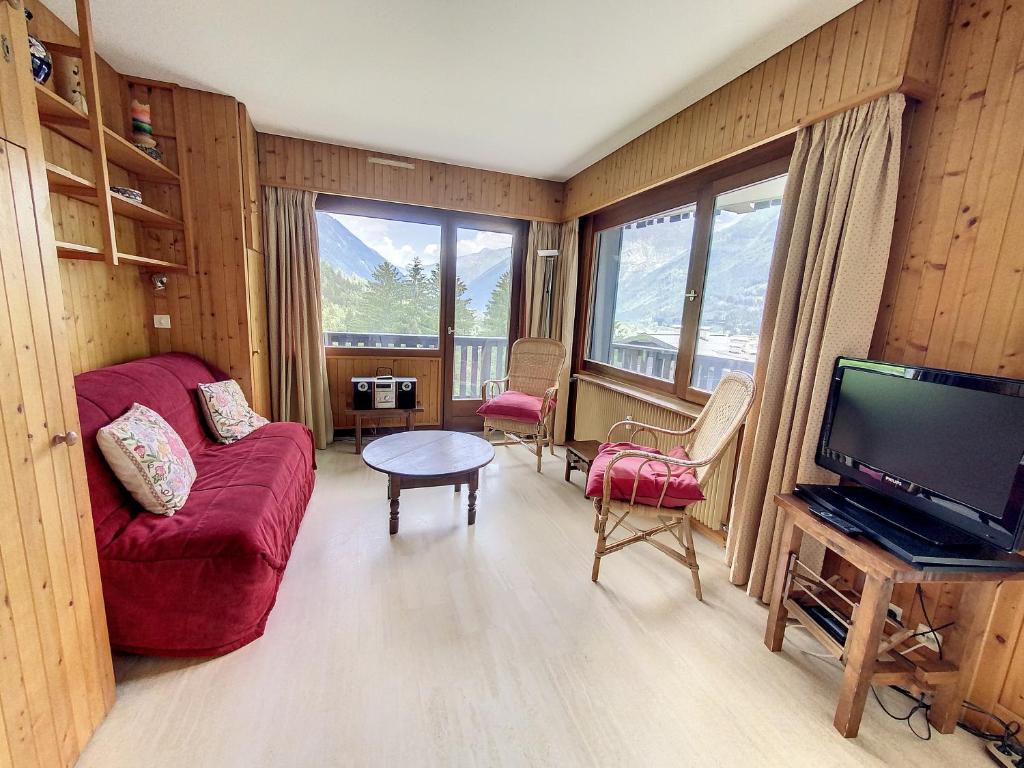 a living room with a red couch and a tv at Caribou Lodge in Chamonix-Mont-Blanc