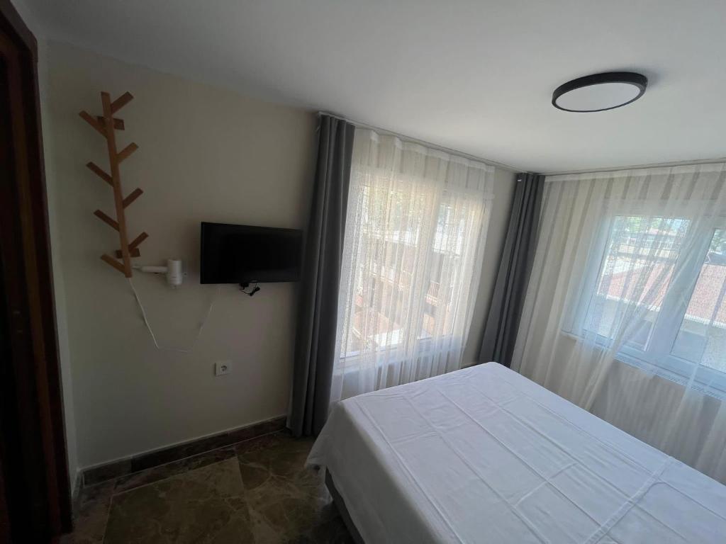 a bedroom with a bed and a flat screen tv at Ada Antik 2 in Adalar
