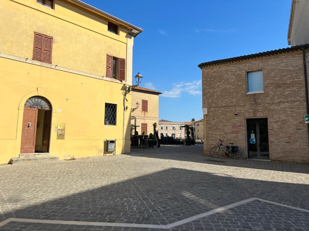 una strada di ciottoli in un vicolo tra due edifici di Residenza del Duca a Senigallia