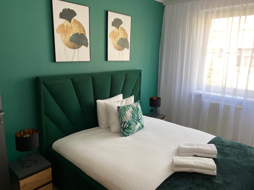 um quarto com uma cama grande e paredes verdes em Blue Apartment close to Old Town em Bydgoszcz