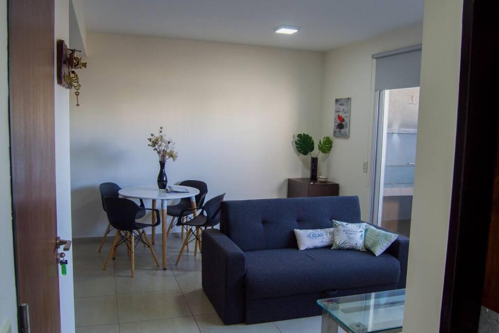 ein Wohnzimmer mit einem blauen Sofa und einem Tisch in der Unterkunft Comodo apartamento en Boedo in Buenos Aires