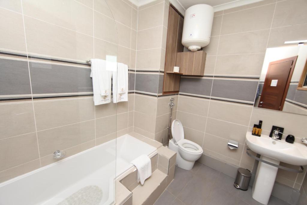 łazienka z toaletą, umywalką i wanną w obiekcie Hotel La Falaise Bonapriso w mieście Duala