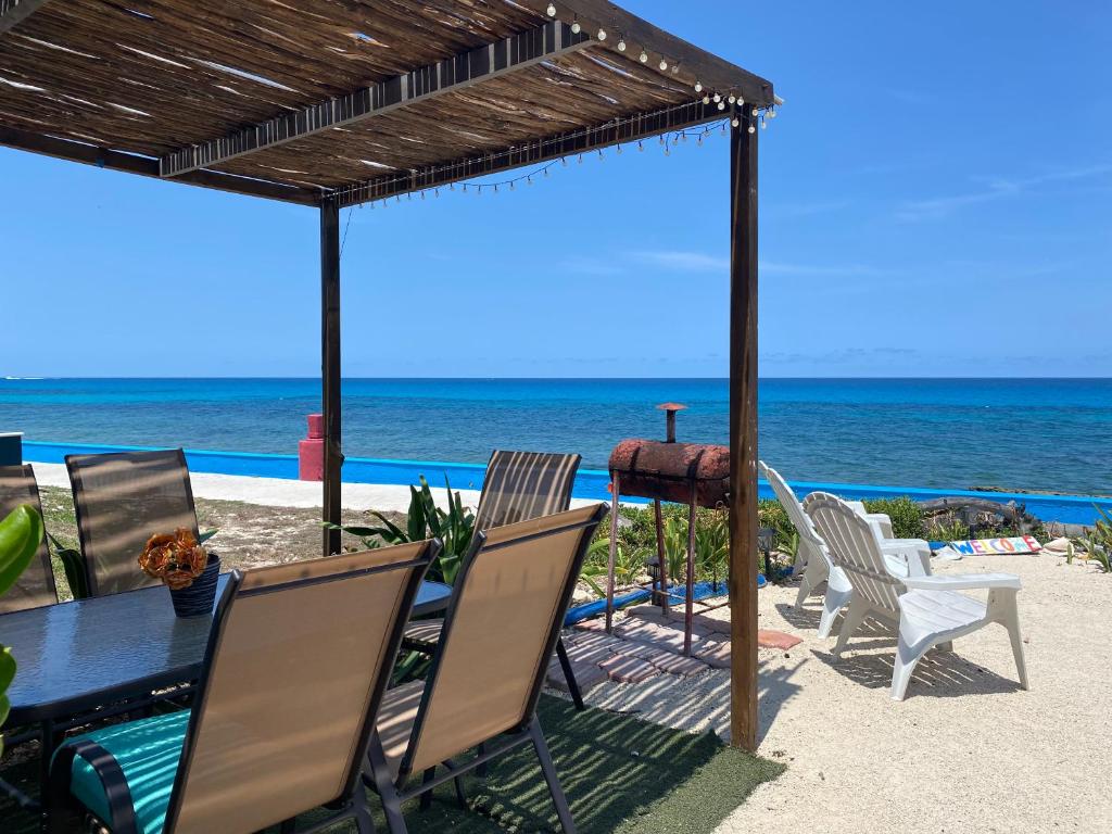 - une table et des chaises sur la plage donnant sur l'océan dans l'établissement "Casitas Arcoiris" Excelente ubicación - Petfriendly, à Isla Mujeres