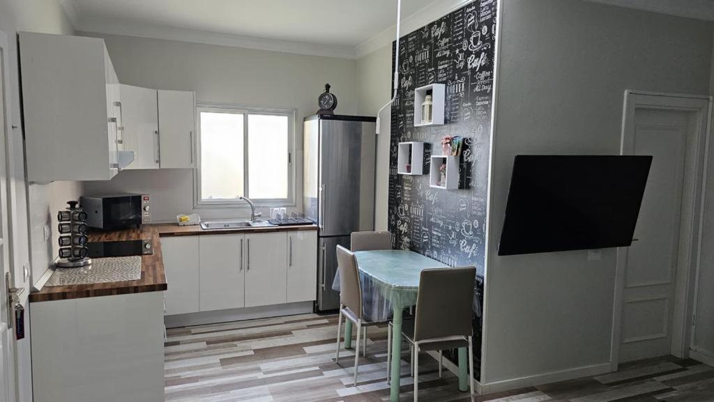 una cucina con tavolo, sedie e frigorifero di Apartamentos GARAKOTA a Telde