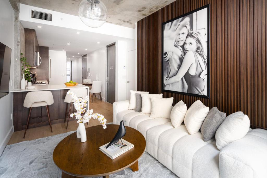 een woonkamer met een witte bank en een tafel bij Stylish Penthouse with Ceiling to Floor Windows in New York