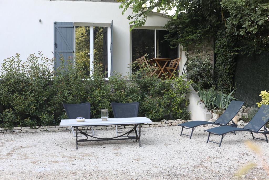 dos sillas y una mesa frente a una casa en Maison calme et verdure, en Saint-Cannat