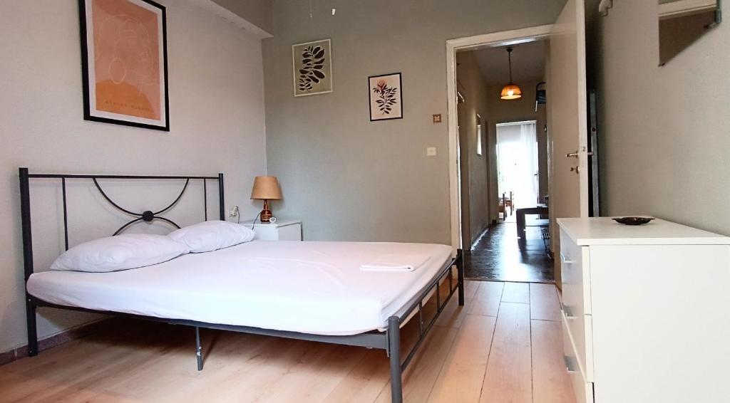 - une chambre avec un lit blanc et un couloir dans l'établissement Long Beach Apartment, à Makrigialos