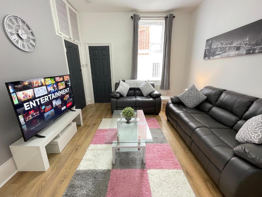 a living room with a couch and a tv at Belford Apartment, Close to Tynemouth in Tynemouth