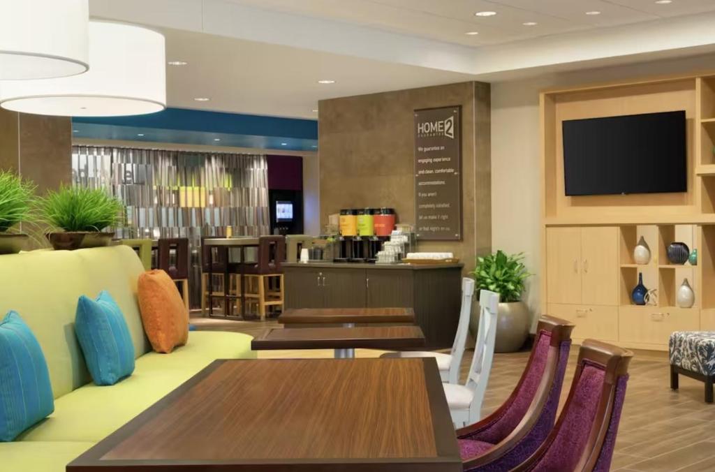 a restaurant with tables and chairs and a tv at Home2 Suites By Hilton Dalton in Dalton