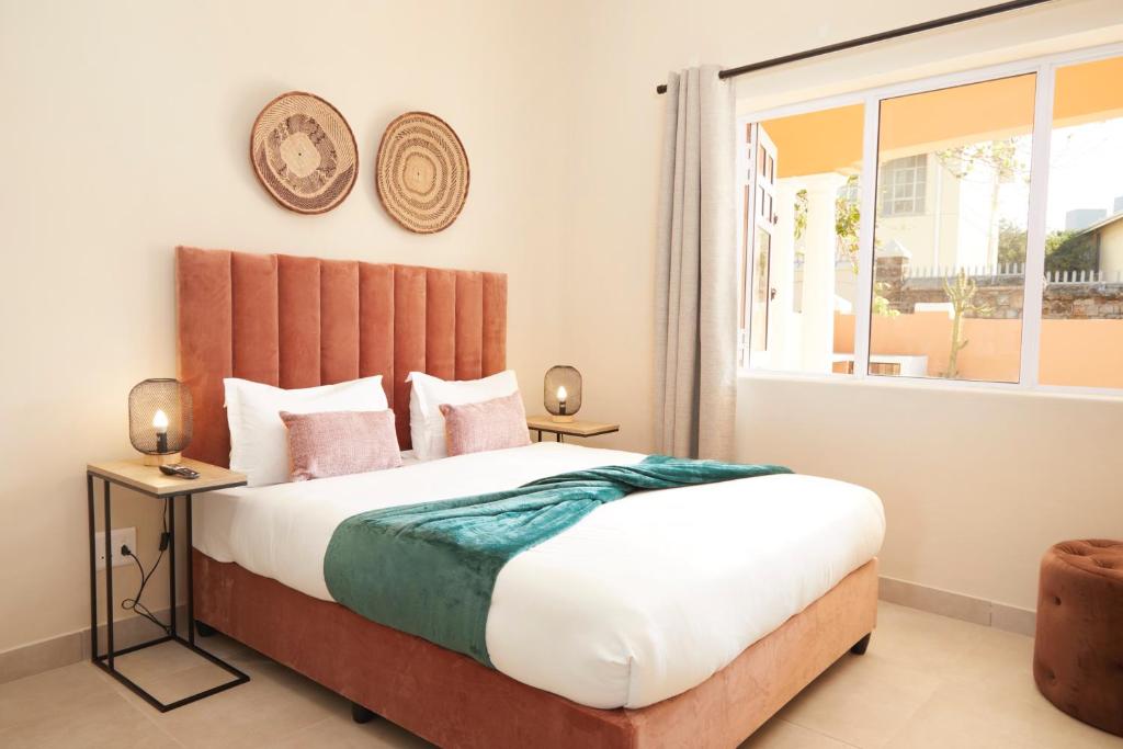 ein Schlafzimmer mit einem großen Bett und einem Fenster in der Unterkunft City Club Guesthouse in Kapstadt