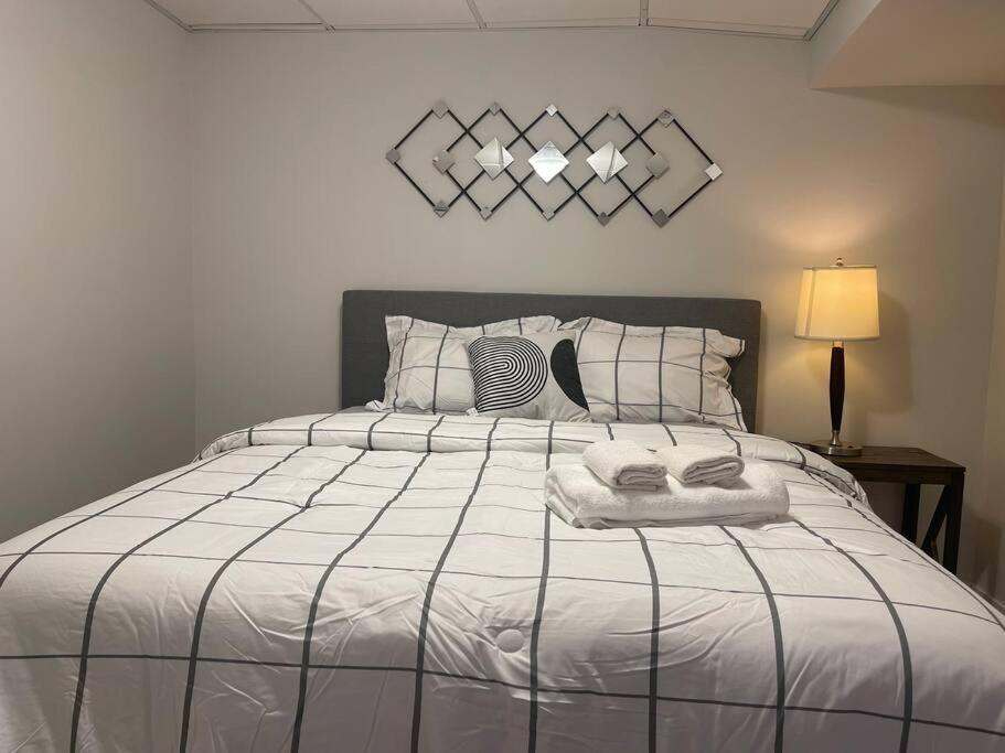 a bedroom with a large bed with white sheets at Fully Furnished CozyTwo Bedroom in Winnipeg