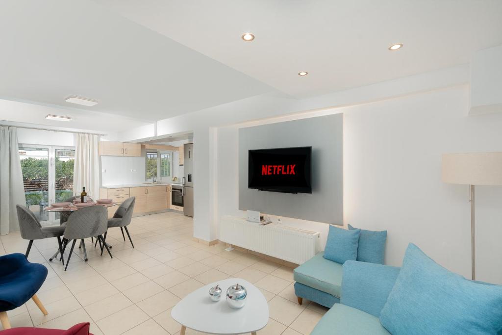 ein Wohnzimmer mit einem blauen Sofa und einem Fernseher in der Unterkunft Livingstone Cottage by A&D Properties in Porto Rafti