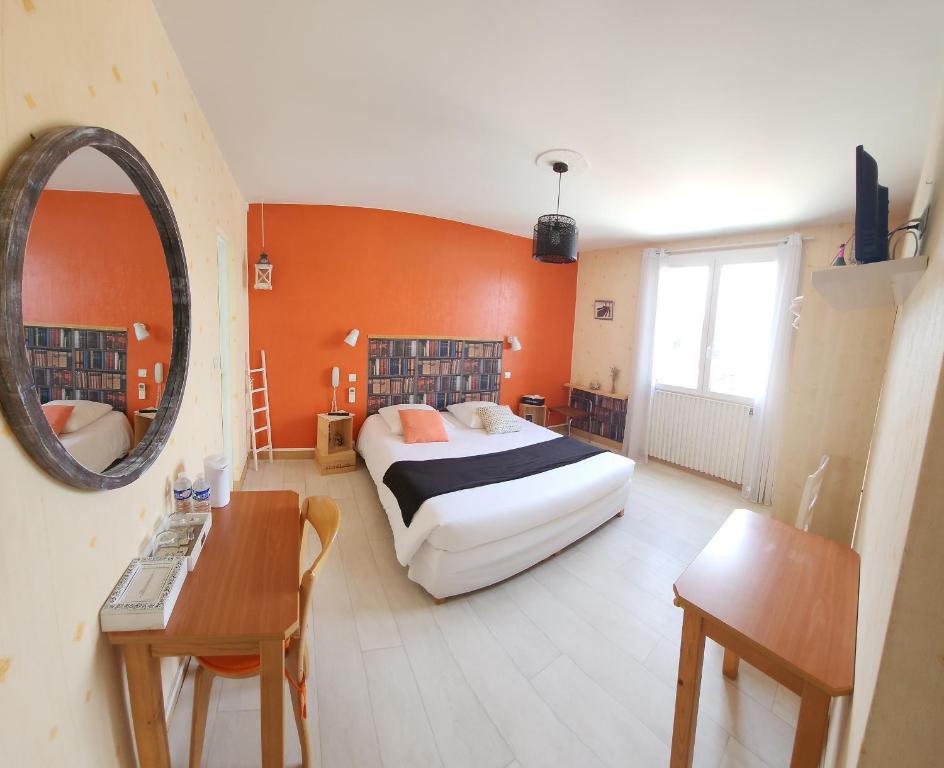 a bedroom with a bed and a mirror and a table at La Limouxine - Mauzac in Limoux