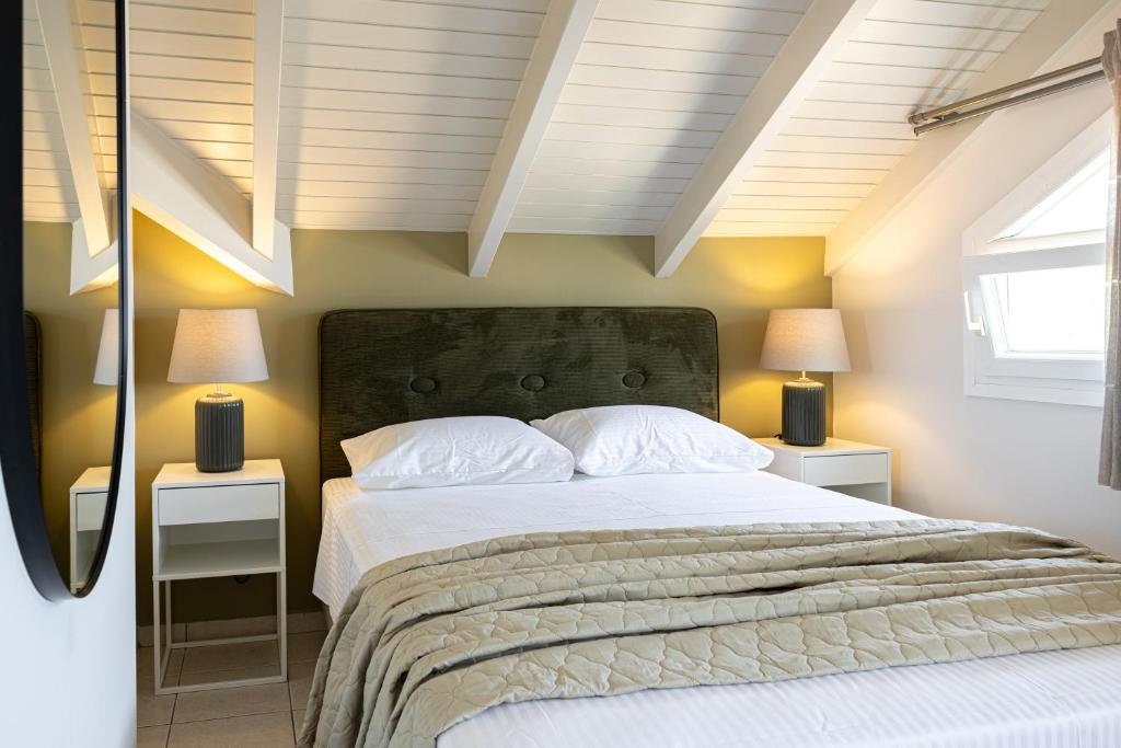 ein Schlafzimmer mit einem großen Bett mit zwei Nachttischen in der Unterkunft Domus City Apartment in Argostoli