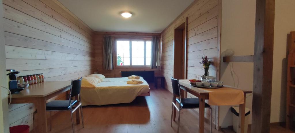 a bedroom with a bed and a desk and a table at Hotel Restaurant Sonnenberg in Mürren