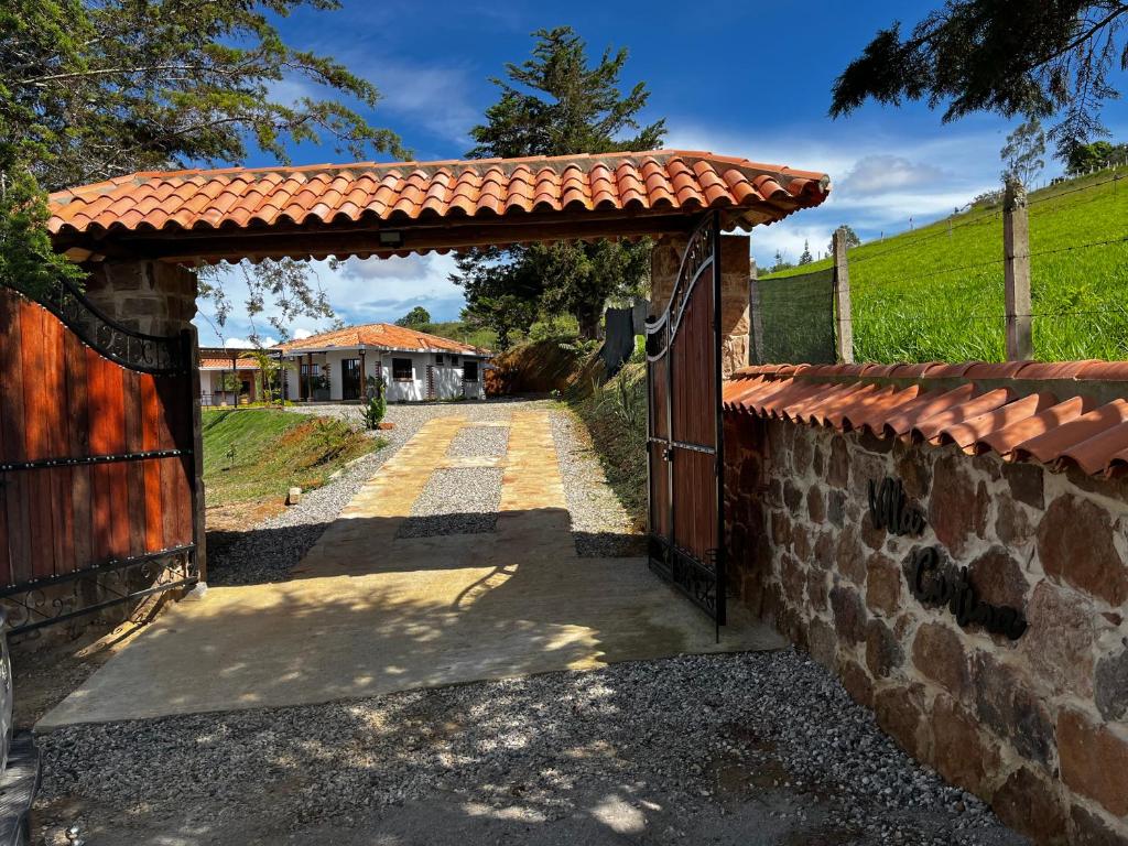 uma entrada para uma casa com um portão e uma parede de pedra em FINCA VILLA CRISTINA em La Fuente