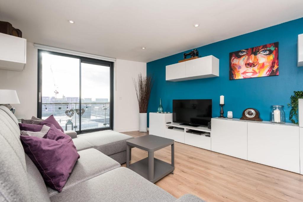 ein Wohnzimmer mit einem Sofa und einem TV in der Unterkunft Host & Stay - The Baltic Penthouse with Balcony in Liverpool