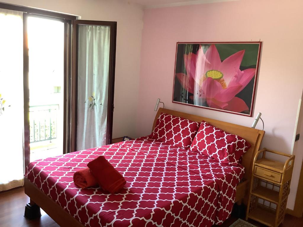 a bedroom with a red bed with a large window at EDYSHOME in Peschiera del Garda