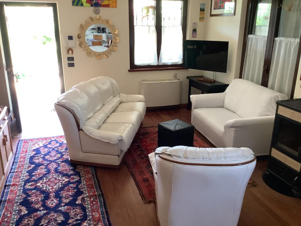 a living room with white furniture and a tv at EDYSHOME in Peschiera del Garda