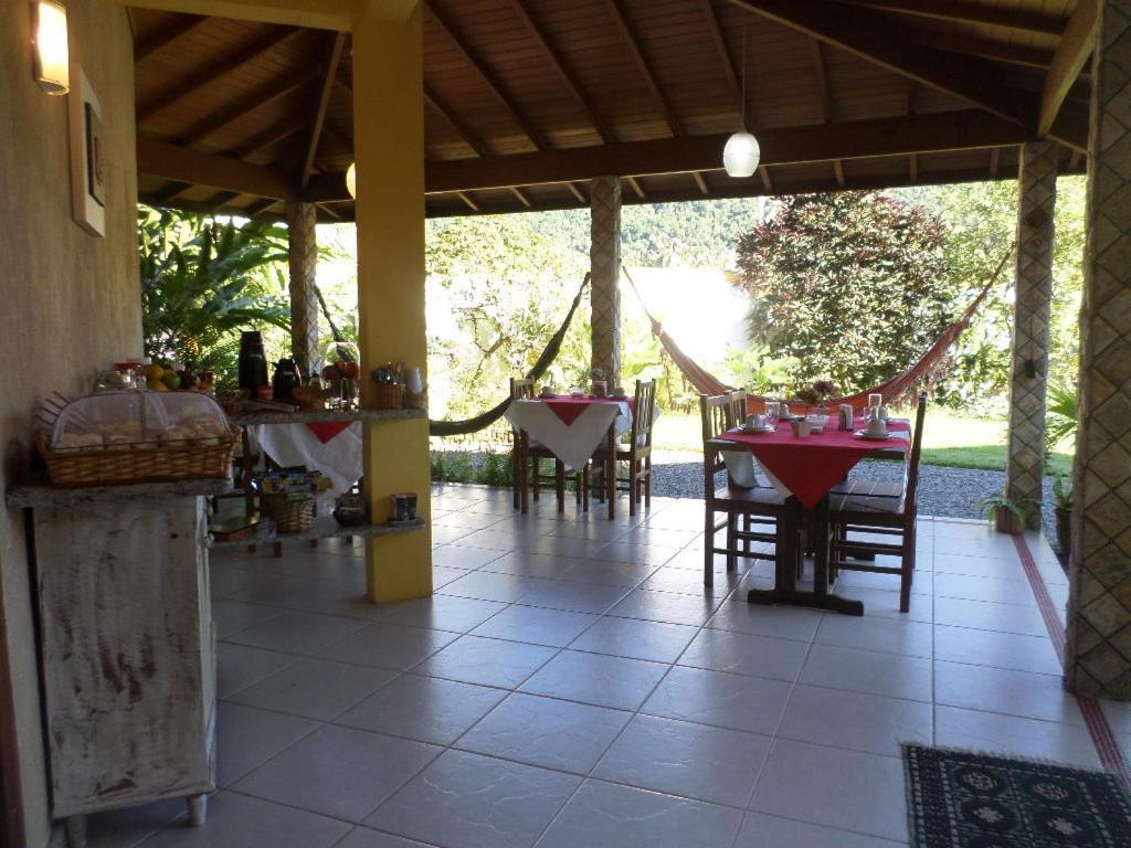 um pátio com mesas e cadeiras numa casa em Pousada Luamar em Paraty