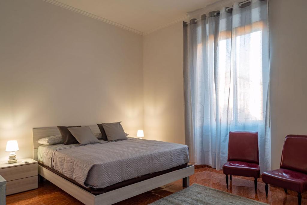 una camera da letto con un letto con due sedie e una finestra di La Maison D'Amelia a Roma