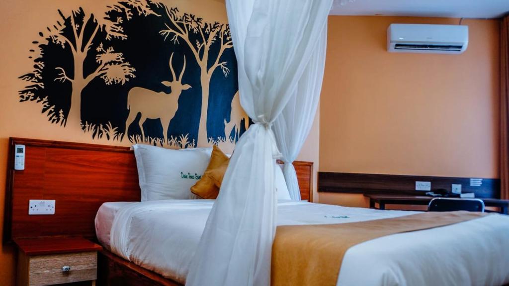 a bedroom with two beds and a painting of a deer at Divine Homes Resort Kisumu in Kisumu