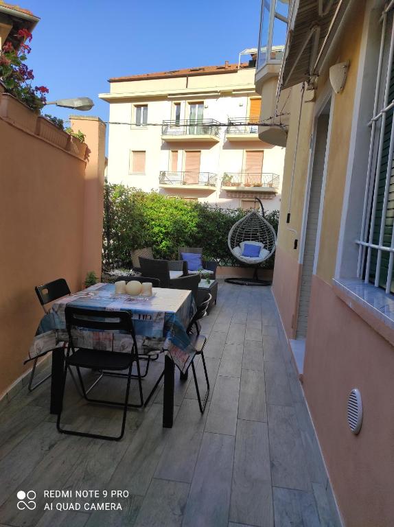 a patio with a table and chairs and a building at La casa dei gelsomini in Alassio