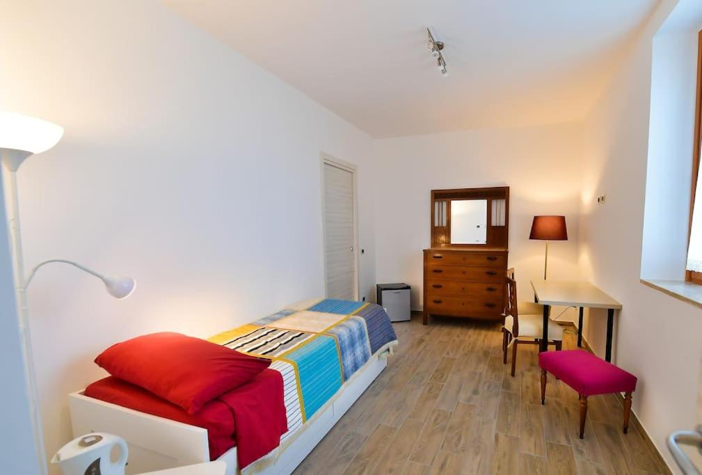 1 dormitorio con cama, escritorio y mesa en La Riggiola, en Salerno