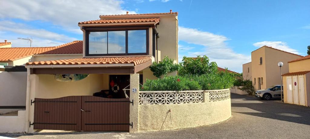 uma casa com uma janela em cima em location maison de vacances jusqu'à 6 personnes près du port et de la plage em Le Barcarès