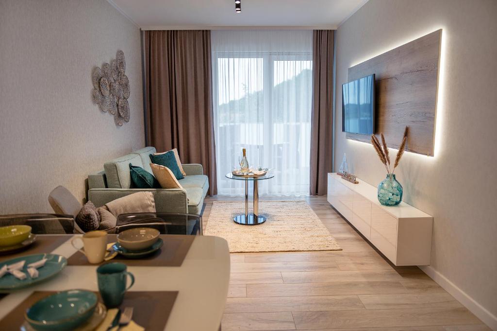 uma sala de estar com um sofá e uma televisão em Platinium Moon - przy samym morzu - Easy-Rent Apartments em Rewal
