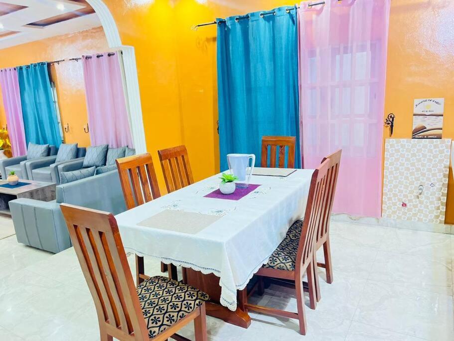 a dining room with a table and chairs at Spacieuse maison à Calavi - Comme chez vous in Abomey-Calavi