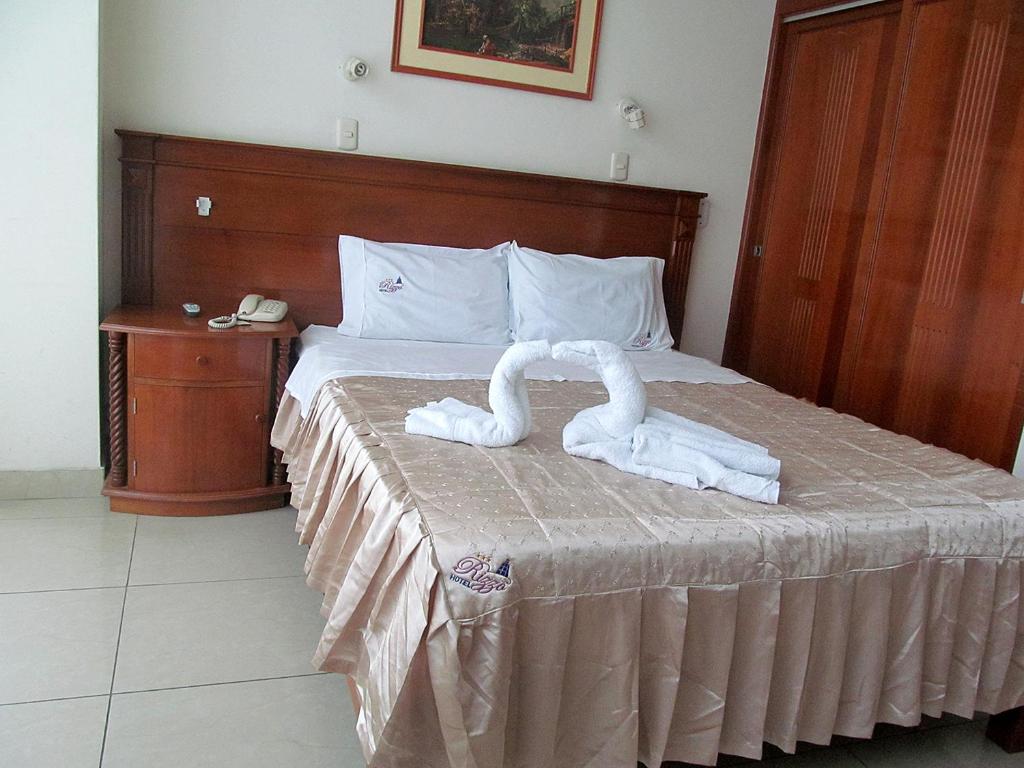 una cama con dos cisnes hechos de toallas en RIZZO HOTEL, en Chiclayo