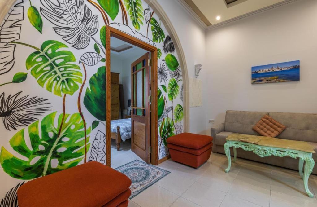 a living room with a mural of plants on the wall at Ta' Marija Home in Sliema
