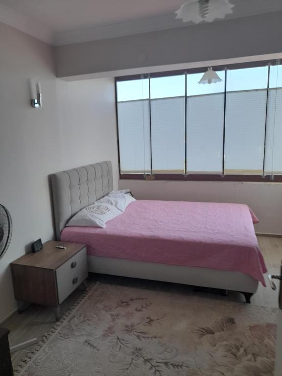 1 dormitorio con cama y ventana grande en IASOS YAZLIK EV, en Milas