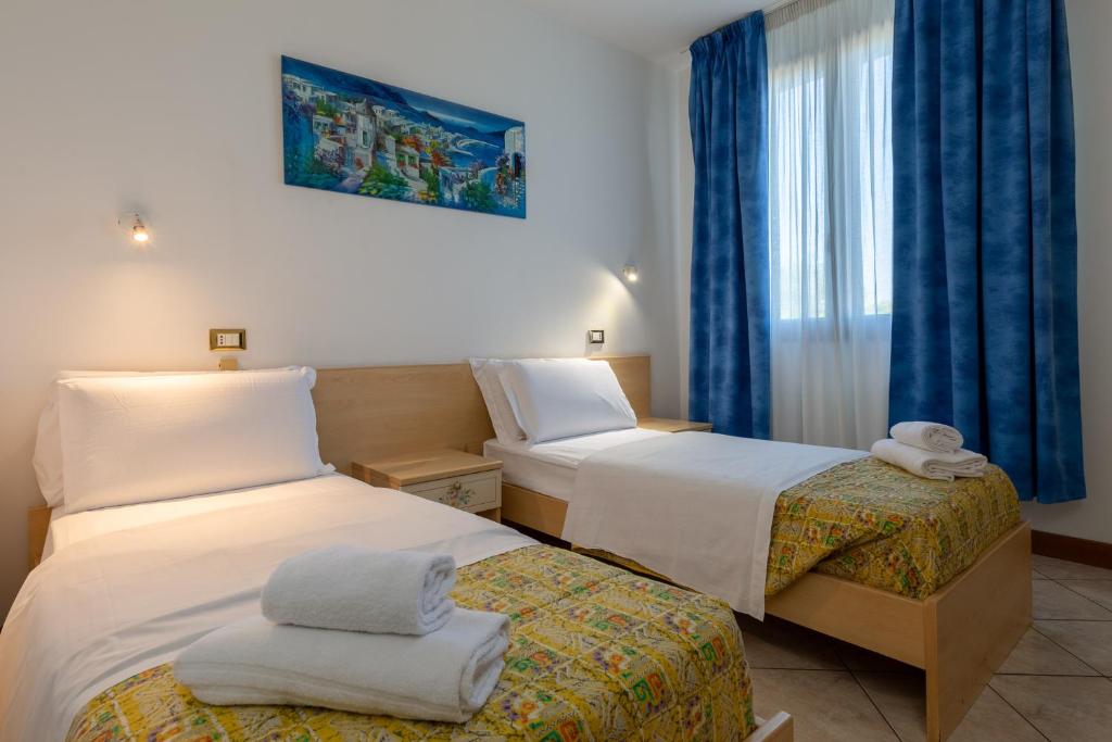 ein Hotelzimmer mit 2 Betten und einem Fenster in der Unterkunft B&B New Aurora Venice in Marghera