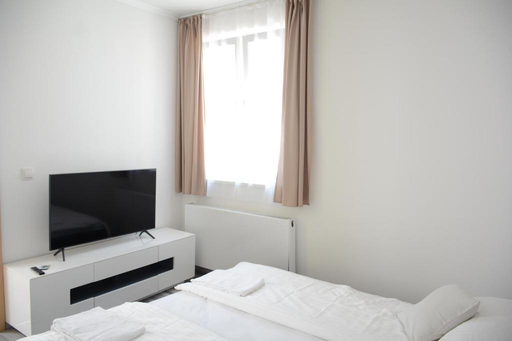 biały pokój z telewizorem i łóżkiem w obiekcie Gästehaus COCO w mieście Krems an der Donau