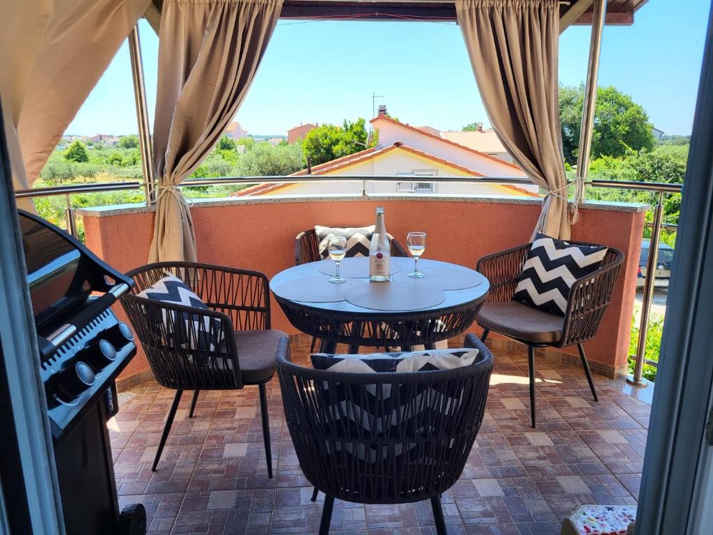 a patio with a table and chairs on a balcony at Apartment Anabella in Fažana
