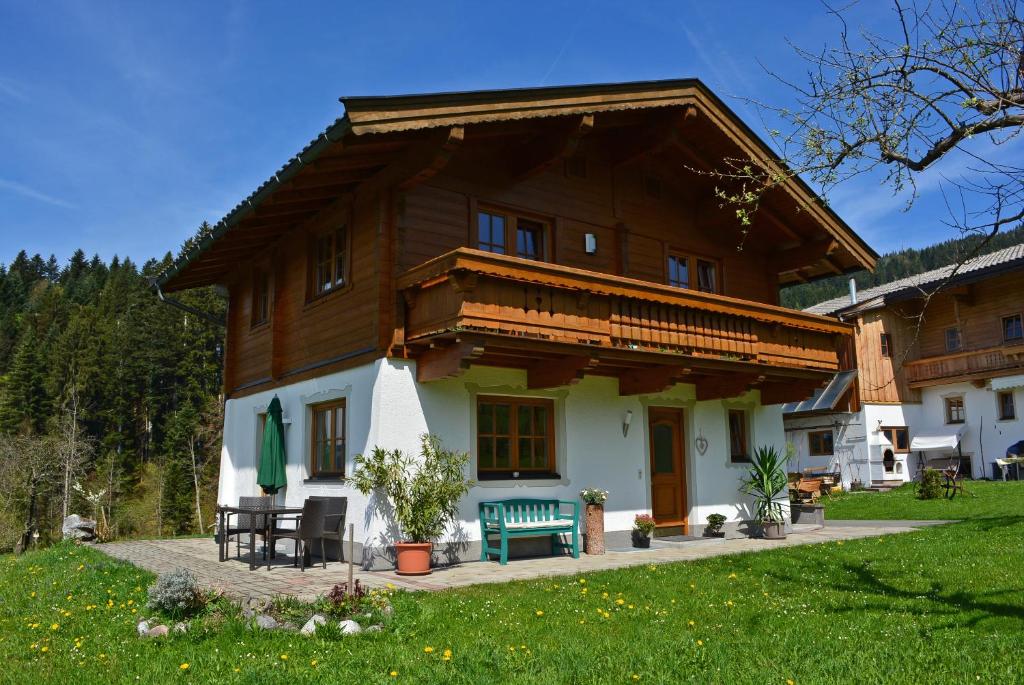 una casa con un banco verde delante de ella en Ferienwohnung Gassoid en Fieberbrunn