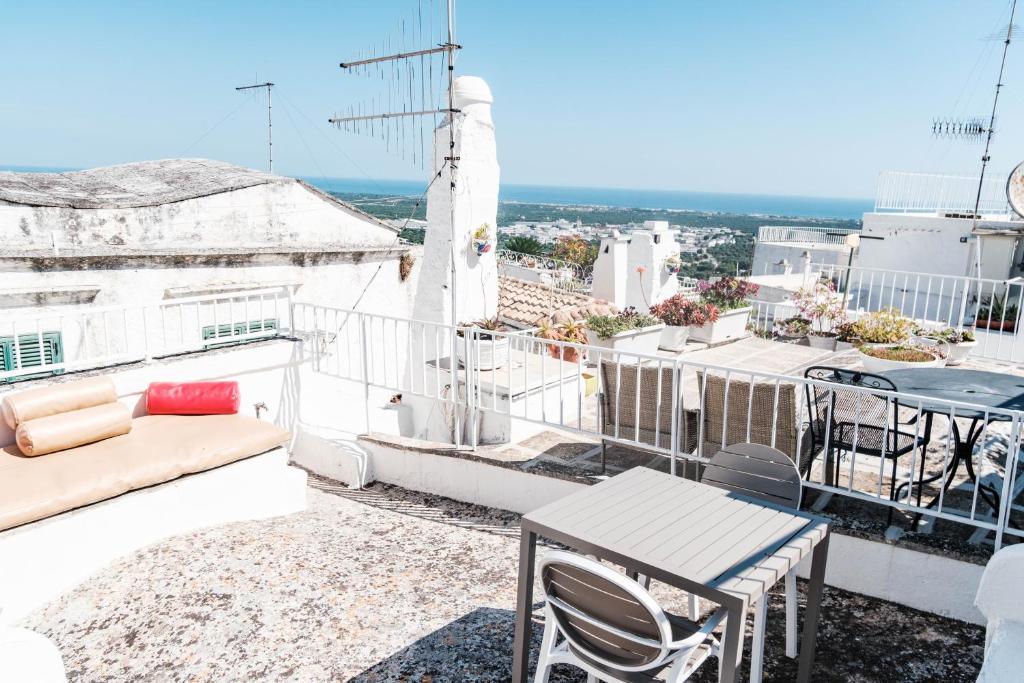 een balkon met een bank, een tafel en stoelen bij Casa Le Mura in Ostuni