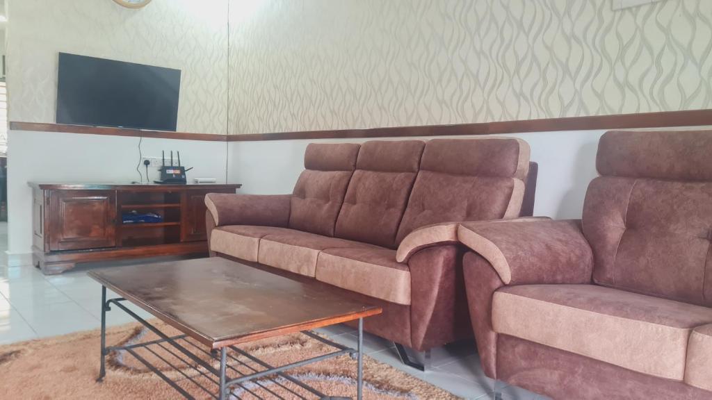 uma sala de estar com um sofá e uma mesa em Anjung KLIA House 31 With Neflix & Airport Shuttle em Banting