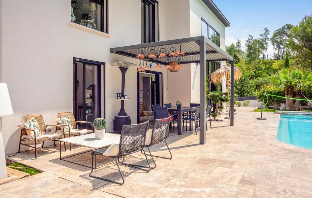 un patio con mesa y sillas junto a una piscina en Nice Home In Gmenos With Outdoor Swimming Pool, Wifi And 4 Bedrooms, en Gémenos