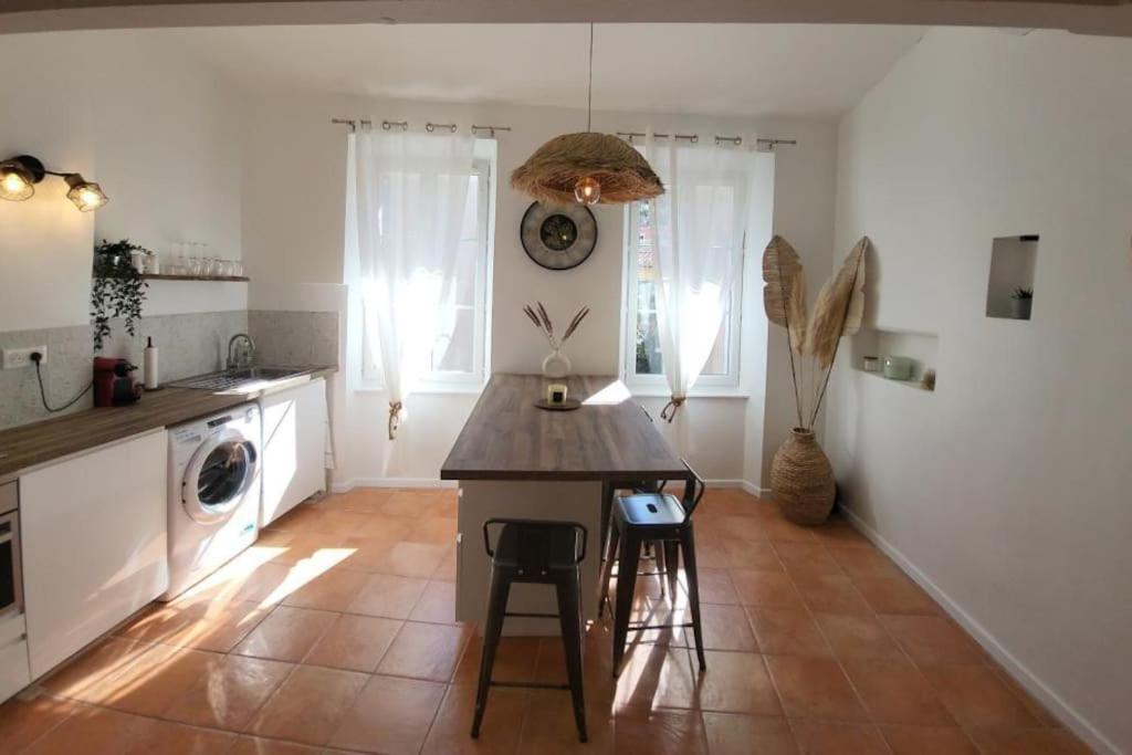 une cuisine avec une table et des chaises dans une pièce dans l'établissement *Blue Éden* Au cœur du village, à Cassis