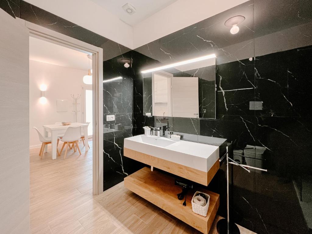 a bathroom with a sink and a black wall at Villa Angelica - Casa Vacanze in Reggio di Calabria
