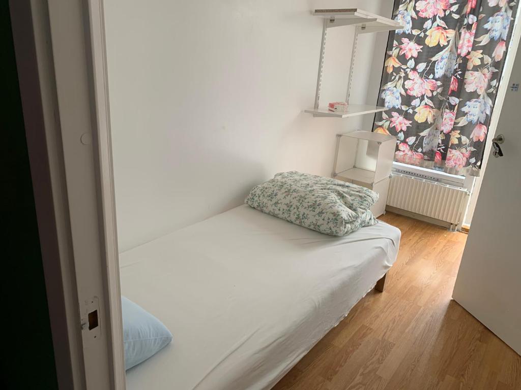 een klein bed in een kamer met een raam bij Vivian house in Göteborg