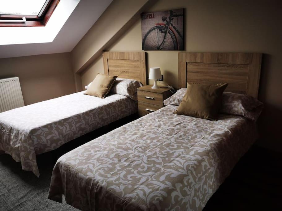 1 dormitorio con 2 camas y una bicicleta en la pared en Ático Río Pego, en Ángeles