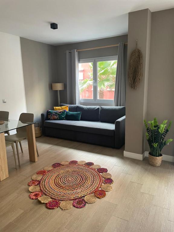 ein Wohnzimmer mit einem Sofa und einem Teppich auf dem Boden in der Unterkunft Boutique Home Canteras in Las Palmas de Gran Canaria