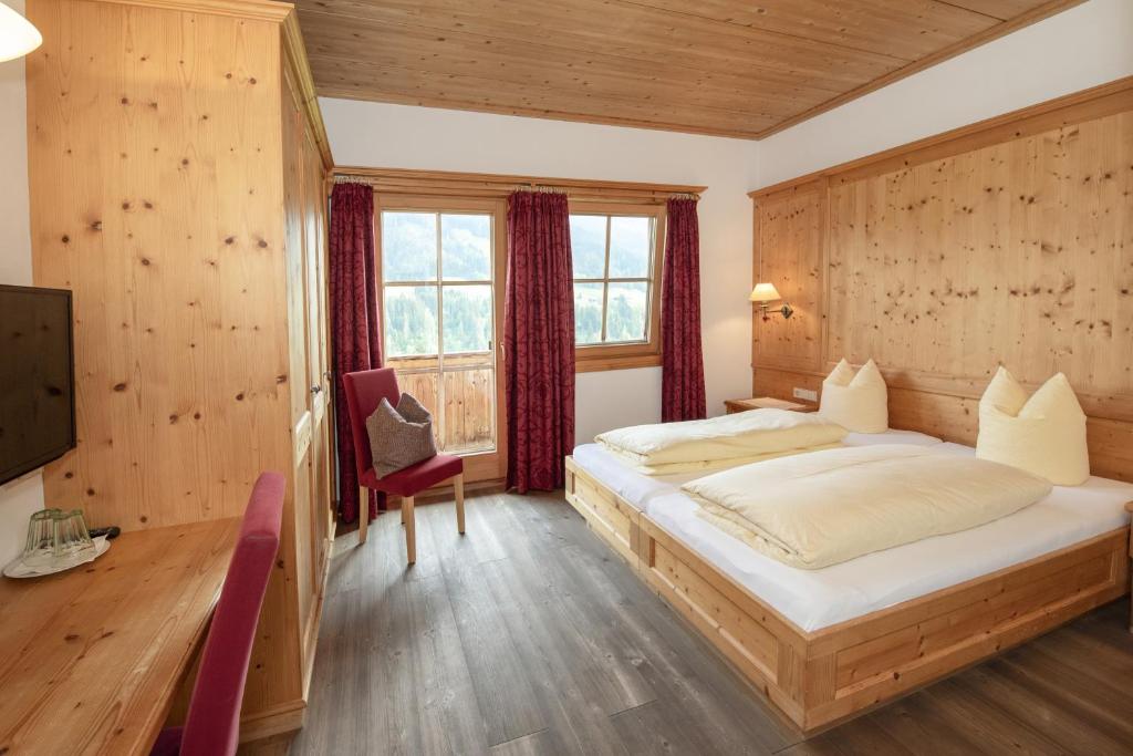 a bedroom with a large bed and a window at Gästehaus Larch in Alpbach