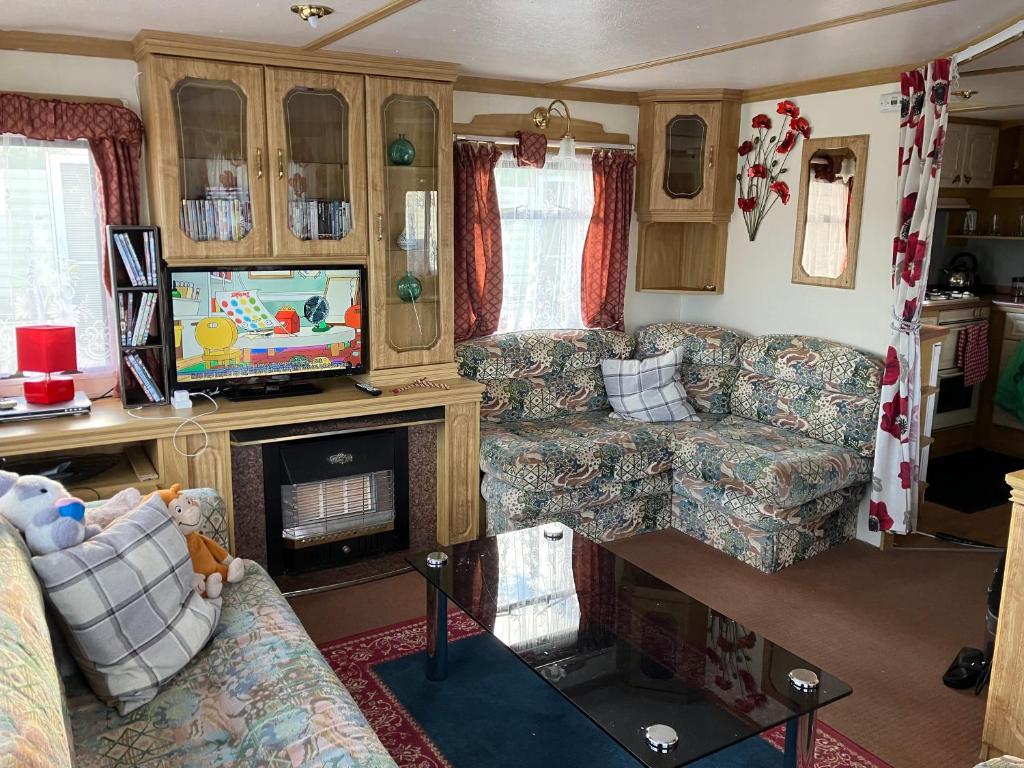 an rv living room with a couch and a television at Caravan 13 Stonehaven recreation grounds in Stonehaven