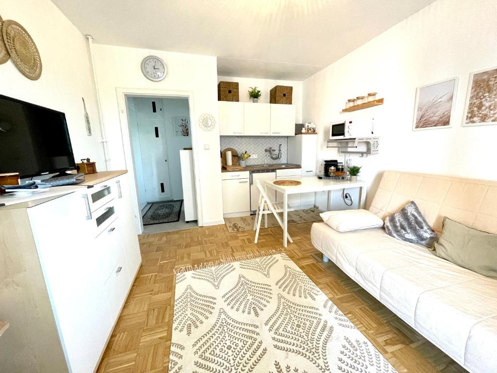 a living room with a white couch and a kitchen at Behagliches Apartment für 2 in Wetzlar