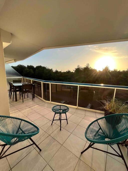 d'un balcon avec trois chaises et une table. dans l'établissement Joie de vivre le touquet, à Le Touquet-Paris-Plage